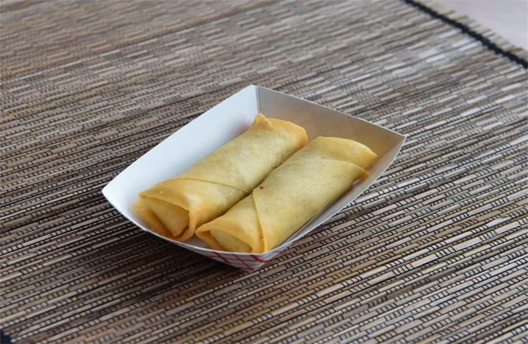 Two crispy golden spring rolls in a takeout box at Panda Chinese Restaurant, a Chinese Restaurant in Detroit